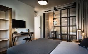 - une chambre avec un lit, un bureau et une télévision dans l'établissement Teku Sardinia Boutique Hotel, à Bari Sardo