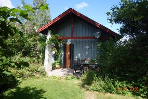 ein Haus mit einem Tisch und einem Stuhl davor in der Unterkunft Ferienhaus Quick's Cottage in Roetgen