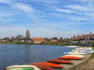 a row of boats are lined up on the water at The Dairy Cottage in Aldeburgh +7 photos