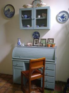 a blue dresser with a chair and plates on the wall at Short Stay De Rode Kers in Harlingen