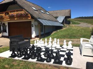 a chess board on a patio in front of a house at Pension Altvogtshof in Eisenbach
