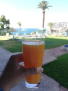 eine Person, die ein Glas Bier hält in der Unterkunft Apartamentos La Roca Rentals in Torremolinos