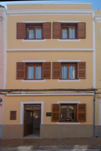 un edificio con ventanas de madera con contraventanas en Sagitario Petit Ciutadella, en Ciutadella