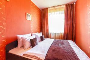モスクワにあるInnDays on Kievskayaのオレンジ色の壁のベッドルーム1室、ベッド1台(枕付)