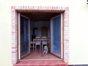 un perro sentado en un porche mirando por la ventana en Apartmány Hradiště, en Znojmo