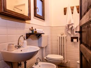 bagno bianco con lavandino e servizi igienici di Alloggio del Fiume - Le Vecchie Vasche a Sassa
