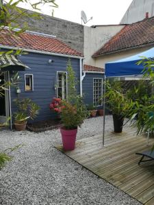 a blue house with potted plants on a wooden deck at Itsara Suites in Le Touquet-Paris-Plage