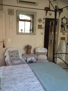a bedroom with a bed and a window and a chair at L'Oustalet in La Tour-dʼAigues