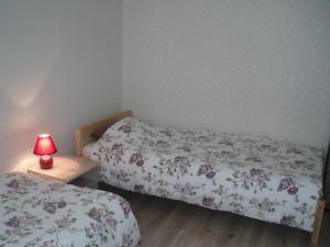 two beds in a room with a lamp on a table at Centra House in Rēzekne +4 photos