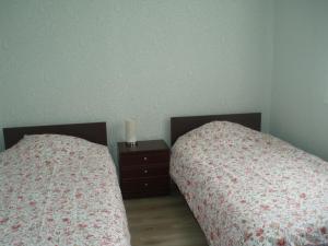 two beds sitting next to each other in a bedroom at Centra House in Rēzekne