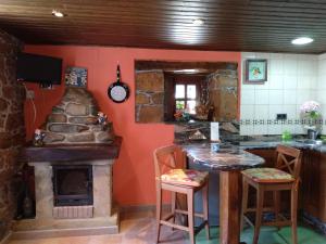 a kitchen with a fireplace and a table and chairs at La Casina de Biescas in Biescas