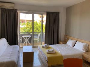 a hotel room with two beds and a balcony at Kleanthi Studios in Chania