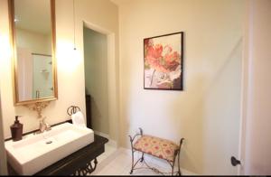 a bathroom with a sink and a mirror and a chair at The Campbell Hotel in Tulsa