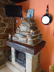 a stone fireplace with two figurines on top of it at La Casina de Biescas in Biescas