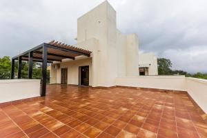vistas a la parte trasera de un edificio con suelo de baldosa en StayVista at Greenwoods Villa 8 with Private Pool, Terrace, Lift & Ping-Pong Table, en Lonavala