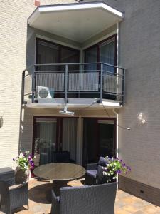 een patio met een tafel en stoelen en een balkon bij La Nuova Casa del Campo (vh De Kamp) in Dinxperlo