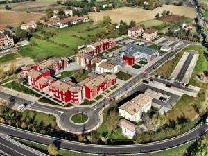 an aerial view of a city with red buildings and a road at Hotel Maranello Village in Maranello