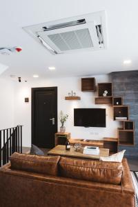 Zivi Nimman في شيانغ ماي: غرفة معيشة مع أريكة جلدية بنية وتلفزيون بشاشة مسطحة