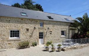 a stone building with potted plants in front of it at Gîte La Bourgetterie Fontenay sur Mer in Fontenay-sur-Mer