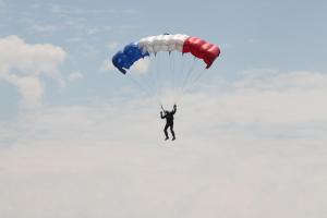 a man is flying through the sky with a parachute at Gîte La Bourgetterie Fontenay sur Mer in Fontenay-sur-Mer