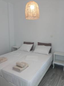 a bedroom with a white bed with towels on it at Daphne in Naousa