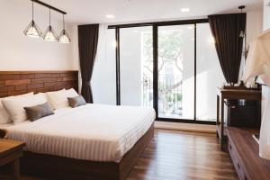 ein Schlafzimmer mit einem Bett und einem großen Fenster in der Unterkunft Zivi Nimman in Chiang Mai