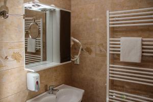 um banheiro com uma pia e um espelho em Apartamente Manó Apartmanok em Praid