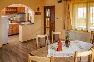 a kitchen and dining room with a table and chairs at Apartamente Manó Apartmanok in Praid