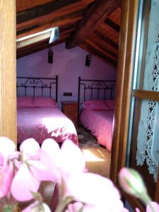 sypialnia z 2 łóżkami i różową pościelą w obiekcie La Casina de Biescas w mieście Biescas