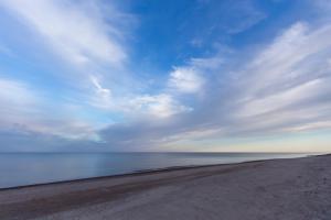 einen Strand mit wolkigem Himmel und Meer in der Unterkunft Jurgi in Pape