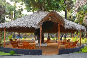 a large straw hut with chairs and tables at Sasvi Cabana in Trincomalee