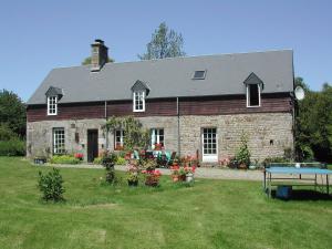 una gran casa de ladrillo con una mesa de ping pong delante de ella en L'Auvraire B&B, en Coulouvray-Boisbenâtre