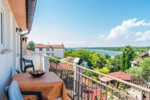 balcón con mesa y vistas al agua en Apartment Vilma Funtana, en Funtana