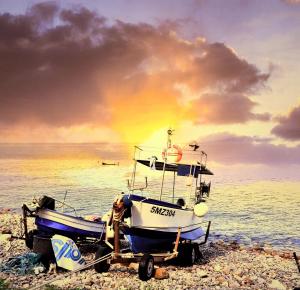 a boat on the beach with a rainbow in the background at Dimora Damare in Caronia Marina
