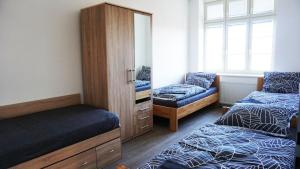 a bedroom with two beds and a dresser and a mirror at Apartment MDK Sokolov in Sokolov