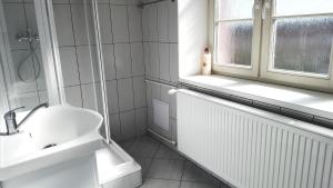 a white bathroom with a sink and a window at Apartment Hornický dům in Sokolov