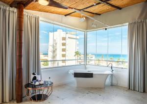 a large bathroom with a large window overlooking the ocean at Essence Hotel Boutique by Don Paquito in Torremolinos