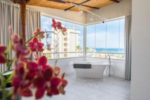 a bathroom with a tub and a large window with the ocean at Essence Hotel Boutique in Torremolinos