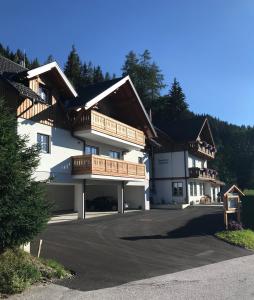 een groot wit gebouw met houten balkons bij Platzhirsch in Haus im Ennstal