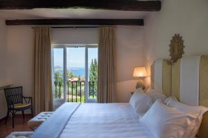 
a bedroom with a large bed and a large window at Il Pellicano in Porto Ercole
