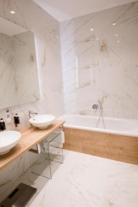biała łazienka z 2 umywalkami i wanną w obiekcie Studio Apartments Opera - Mai's Apartments w Wiedniu +37 zdjęć