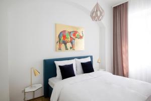 sypialnia z łóżkiem i obrazem słonia na ścianie w obiekcie Studio Apartments Opera - Mai's Apartments w Wiedniu