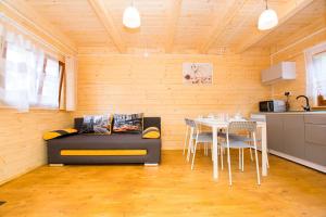 ein Wohnzimmer mit einem Sofa und einem Tisch in der Unterkunft Domki KARO in Rowy