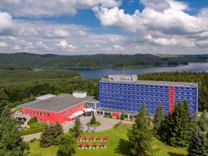 eine Luftansicht eines Hotels mit See in der Unterkunft Hotel Am Bühl in Eibenstock