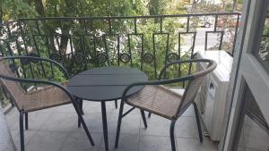 a table and two chairs on a balcony at Sugár apartman in Debrecen