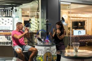 a man and a woman are drinking from drinking glasses at Essence Hotel Boutique in Torremolinos