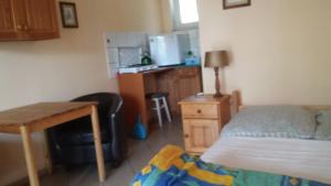 a bedroom with a bed and a desk and a kitchen at Agroturystyka Zatom Stary in Zatom Stary