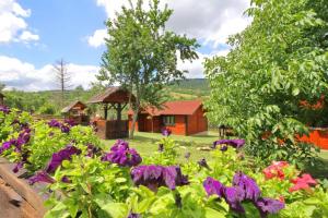 a garden with purple flowers and a gazebo at Malo selo Bojanovići in Golovo