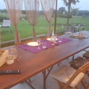 a wooden table with wine glasses and a bottle at Ca' Blanca in Castelnuovo del Garda