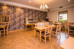 a dining room with wooden tables and chairs at Bed & Breakfast Karun in Cerklje na Gorenjskem